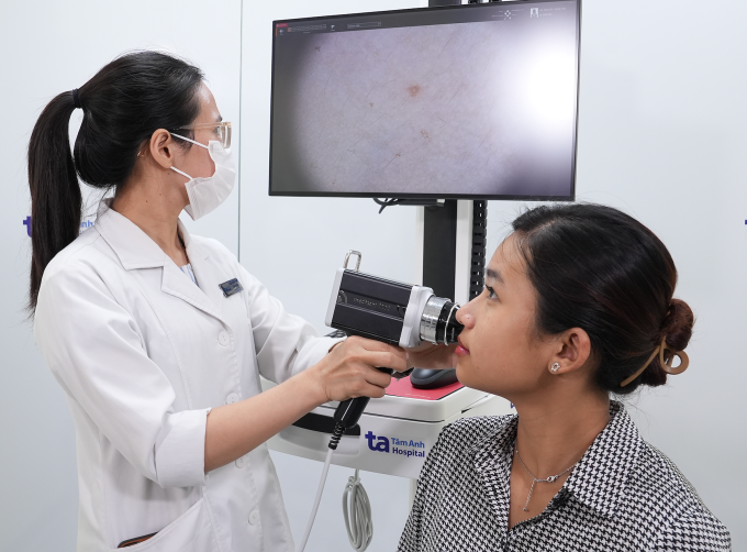 Bác sĩ khoa Da liễu soi da cho một người bệnh sau điều trị mụn trứng cá. Ảnh minh họa: Bệnh viện Đa khoa Tâm Anh