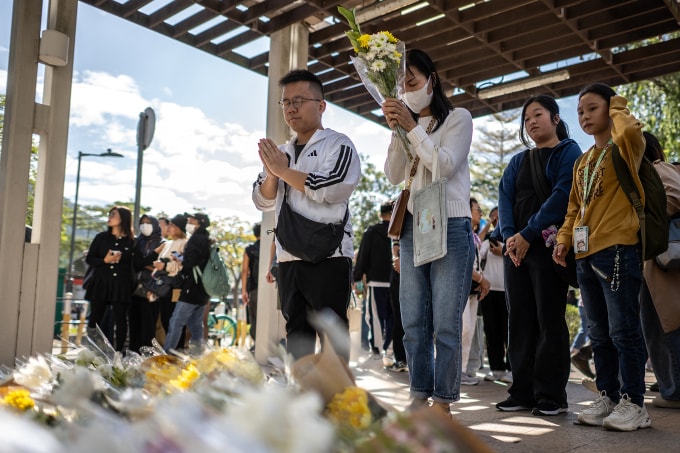 Người dân đặt hoa tưởng niệm các nạn nhân vụ cháy cụm chung cư Wang Fuk Court tại khu vực tưởng niệm ngày 29/11. Ảnh: AFP