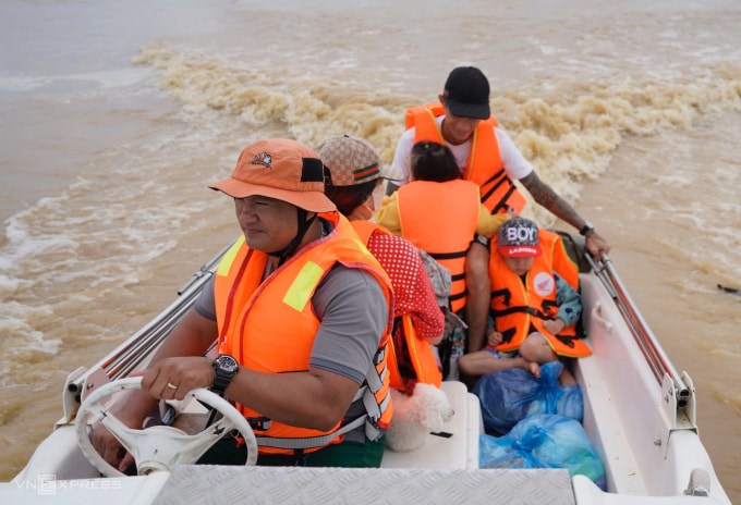 Anh Trung lái xuồng cứu hộ đưa một gia đình thoát khỏi ngập sâu ở Nam Phước, cách Hội An khoảng 7 km trong đợt lụt cuối tháng 10 ở miền Trung. Ảnh: Nguyễn Đông