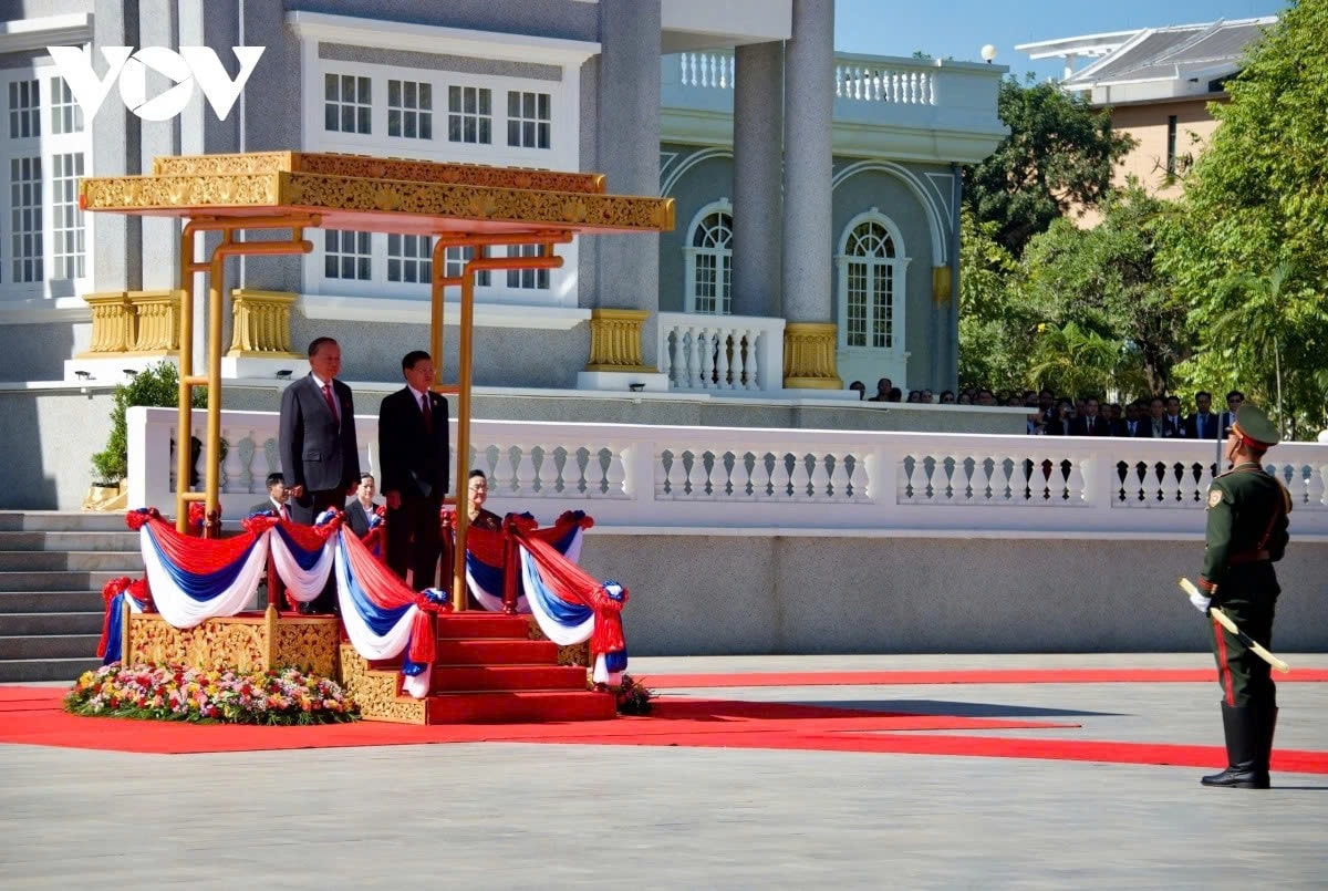 Tổng Bí thư, Chủ tịch nước Lào Thongloun Sisoulith mời Tổng Bí thư Tô Lâm bước lên bục danh dự. Quân nhạc cử Quốc thiều hai nước.