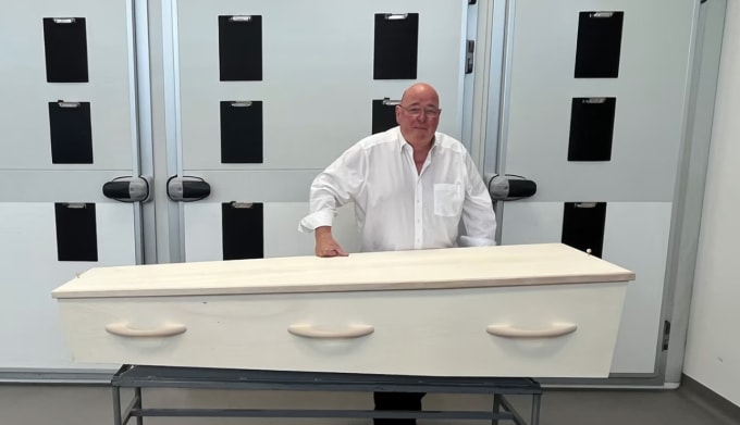 Ben Vos đứng cạnh cỗ quan tài tại nơi làm việc gần sân bay Hà Lan. Ảnh: CNN