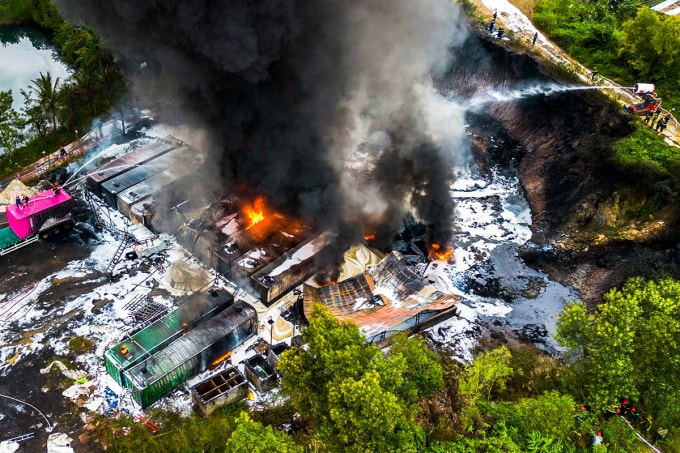 Cảnh sát tiếp cận đám cháy từ nhiều hướng, trong đó robot chữa cháy tận dụng địa hình bãi xe có vách đồi núi cao để phun nước và bọt xuống phía dưới. Ảnh: Ngọc Trường