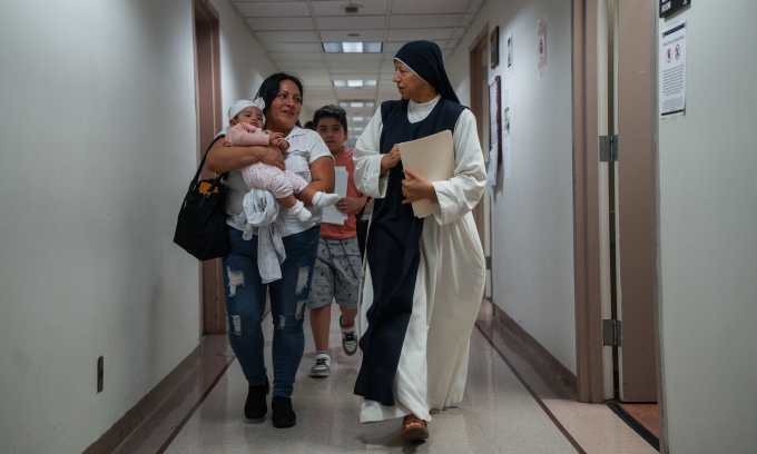 Một nữ tu đi cùng hai người tị nạn trong tòa án di trú ở New York, Mỹ hôm 28/11. Ảnh: AP