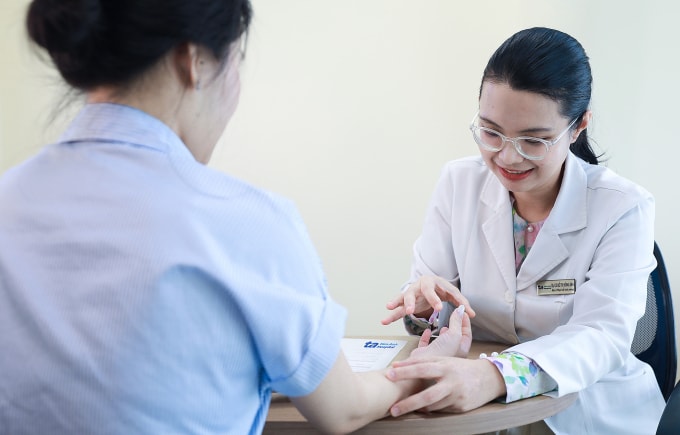 Bác sĩ Ánh kiểm tra tình trạng chức năng tay người bệnh. Ảnh: Bệnh viện Đa khoa Tâm Anh