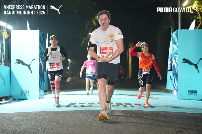 Baptiste Larnaudie tạo dáng trước ống kính khi chạy qua Puma zone trên đường chạy 21km. Ảnh: VnExpress Marathon