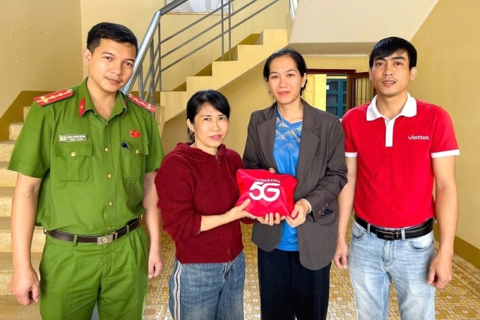 Gia đình bà Vàng (bên phải) nhận túi và toàn bộ số tiền từ bà Huế ở trụ sở công an. Ảnh: Công an xã Sơn Hà