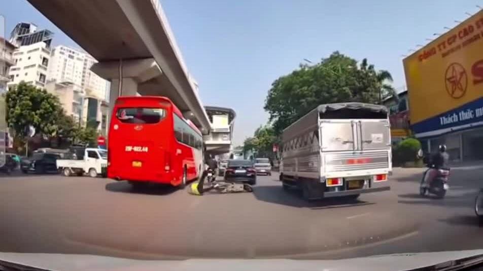 Người đi xe máy thoát chết dưới bánh xe khách