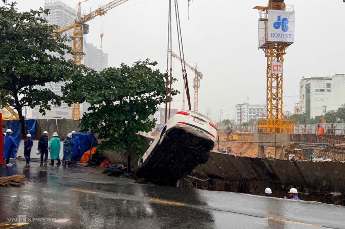 Xe cầu đưa hai ô tô từ dưới hố tử thần lên. Ảnh: Nguyễn Đông