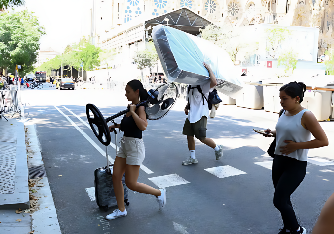 Người dân Tây Ban Nha vận chuyển quạt ở Barcelona. Ảnh: Reuters