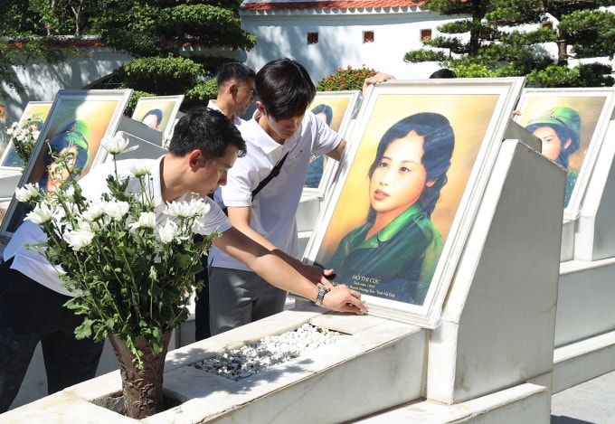 Các thành viên nhóm đặt chân dung và thắp hương trên mộ liệt sĩ Hồ Thị Cúc tại Khu di tích Ngã ba Đồng Lộc, Hà Tĩnh năm 2022. Ảnh: Skyline