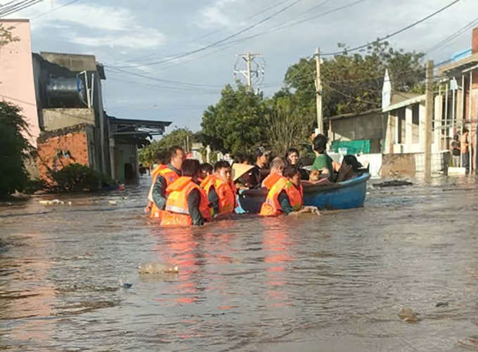 Lực lượng chức năng di dời dân ở thôn Phước Thể, xã Liên Hương trong vùng bị ngập, sáng 4/12. Ảnh: Long Hương
