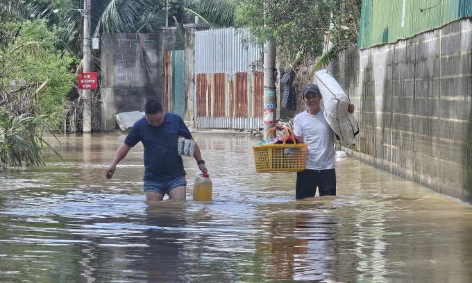 Người dân trên đường Nguyễn Lương Bằng, phường Bắc Nha Trang, di dời vật dụng do nước ngập sâu, sáng 4/12. Ảnh: Bùi Toàn