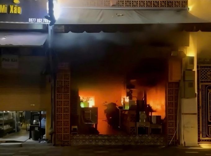 Khói lửa cháy đỏ rực ở tầng trệt của quán ăn, bên trong quán có dựng nhiều xe máy, bàn ghế, bếp. Ảnh: Minh Bằng