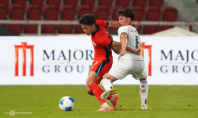 Pha tranh chấp giữa cầu thủ Timor Leste (áo trắng) và Singapore. Ảnh: Đức Đồng