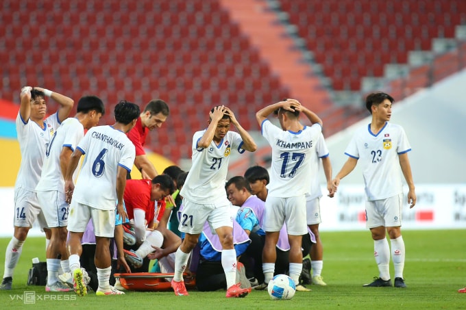 Các cầu thủ Lào ôm đầu khi chứng kiến chấn thương nặng của Phetdavanh Somsanid. Ảnh: Đức Đồng