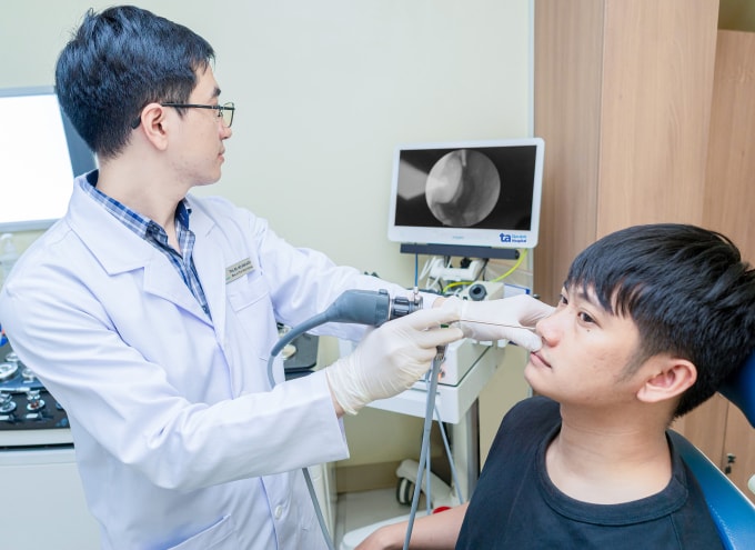 Bác sĩ Hữu đang nội soi mũi cho một người bệnh. Ảnh: Bệnh viện Đa khoa Tâm Anh