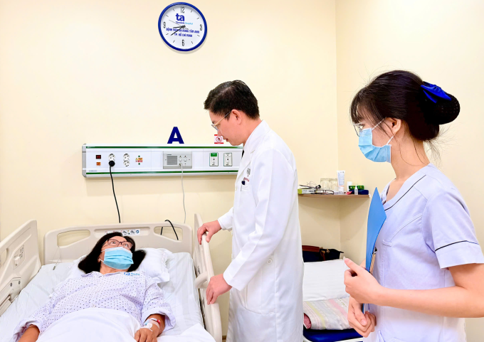 Bác sĩ Công Khánh (thứ hai từ phải qua) thăm bà Loan sau ca phẫu thuật robot. Ảnh: Bệnh viện cung cấp