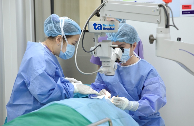 Bác sĩ Phúc (phải) phẫu thuật loại bỏ mộng thịt mắt phải cho bà Thùy. Ảnh: Bệnh viện Đa khoa Tâm Anh