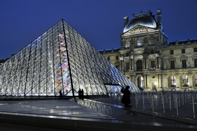 Kim tự tháp bằng kính, kiến trúc biểu tượng của bảo tàng Lourve tại Paris, được thắp sáng trong đêm 2/12. Ảnh: AFP
