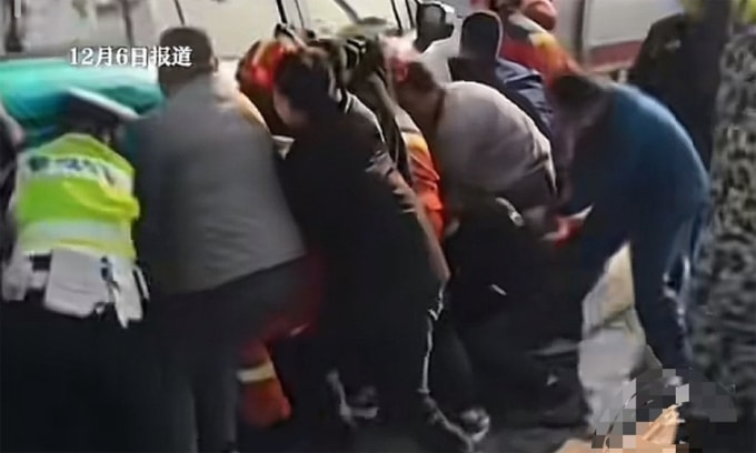 Một nạn nhân kẹt dưới gầm xe, được người dân và cảnh sát hợp sức nâng xe giải cứu. Ảnh từ video.