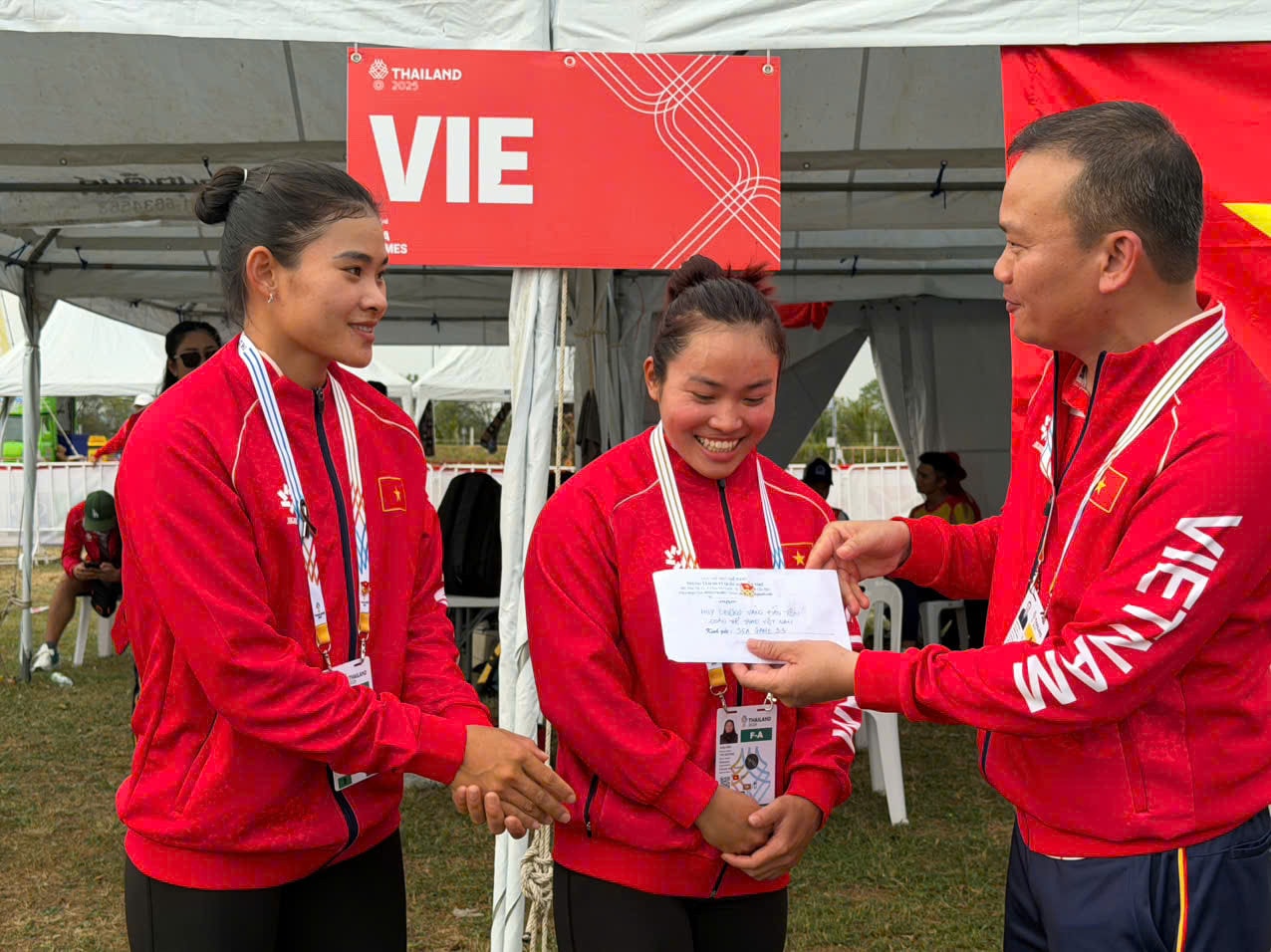 Trưởng đoàn thể thao Việt Nam Nguyễn Hồng Minh trao thưởng nóng 10 triệu đồng cho Diệp Thị Hương, Nguyễn Thị Hương.