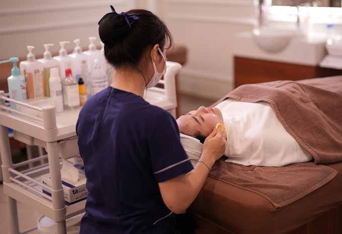 Kỹ thuật viên khoa Thẩm mỹ đang chăm sóc da cho một phụ nữ. Ảnh: Bệnh viện cung cấp