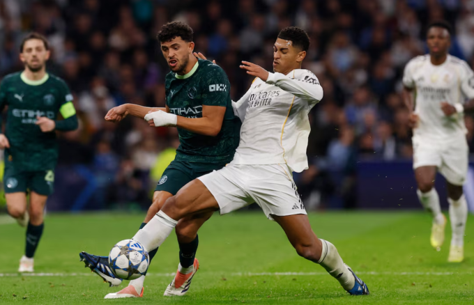 Jude Bellingham (phải) tranh chấp với Matheus Nunes. Ảnh: Reuters