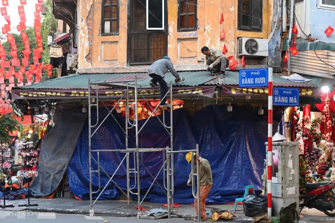 Lực lượng chức năng tháo dỡ phần mái che lấn ra vỉa hè ở đầu phố Hàng Mã – Hàng Rươi hôm 24/11. Ảnh: Giang Huy