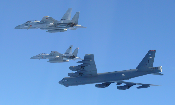 Tiêm kích F-15 Nhật Bản và oanh tạc cơ B-52 Mỹ (dưới) trong cuộc diễn tập hôm 10/12. Ảnh: BQP Nhật Bản