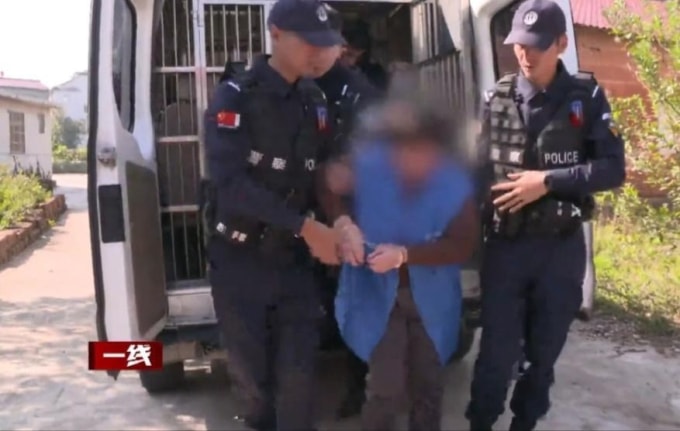 Phan bị cảnh sát áp giải đến hiện trường vụ án 27 năm trước. Ảnh: CCTV