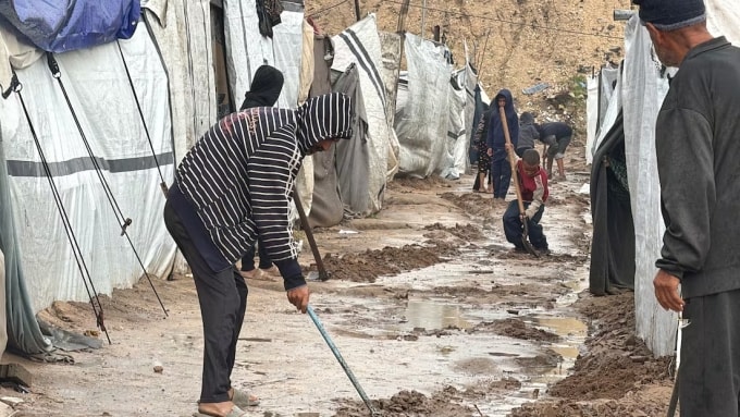 Người dân thành phố Gaza dọn dẹp lối đi sau trận lụt ngày 10/12. Ảnh: CBC