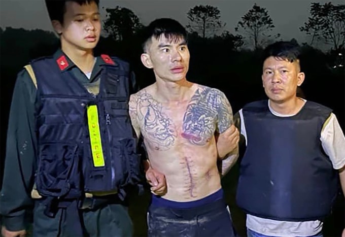 Lý Văn Vũ (cởi trần) khi bị bắt tại khu đồi ở Phú Thọ, ngày 15/1/2024. Ảnh: Công an cung cấp