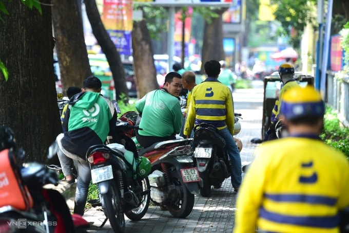 Tài xế xe công nghệ chờ khách trên đường tại trung tâm TP HCM, ngày 24/5. Ảnh: Thanh Tùng