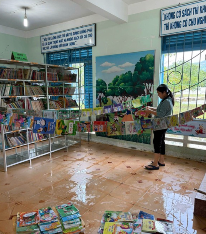 Cô giáo tại trường TH Cam Hoà 1 đang phơi sách vở của học sinh bị ngâm nước. Ảnh: Nhà trường cung cấp
