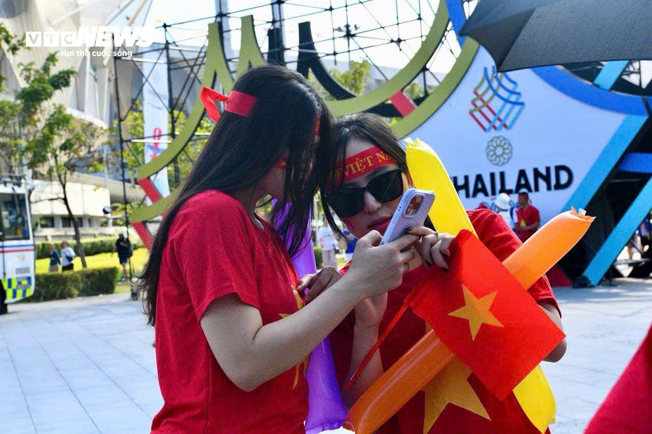 Họ vừa kiểm tra ảnh, kiểm tra lại vé vào sân và thông tin trận đấu. Vé môn bóng đá nam có sử dụng hình thức mã QR Code để vào sân.