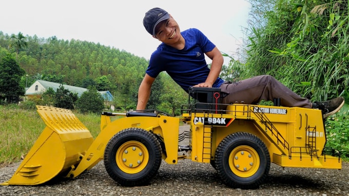 Anh Hùng và chiếc xe máy xúc lật (wheel loader) CAT 994K phiên bản thu nhỏ do bản thân chế tạo. Ảnh: Nhân vật cung cấp