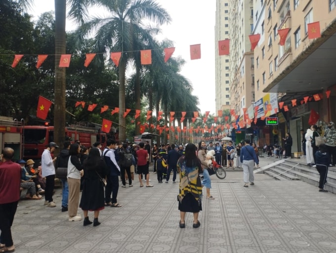 Người dân khu chung cư di tản xuống sân. Ảnh: Việt An