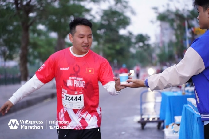 Runner được tình nguyện viên tiếp nước trên đường chạy VnExpress Marathon Hải Phòng 2024. Ảnh: VnExpress Marathon