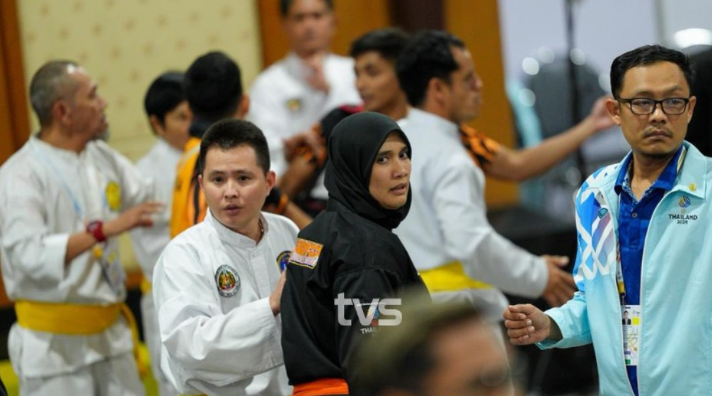 Huấn luyện viên Siti Rahmah Mohamed Nasir (áo đen) được nhân viên điều hành dẫn ra khỏi khu vực trọng tài. (Nguồn: Sarawak)