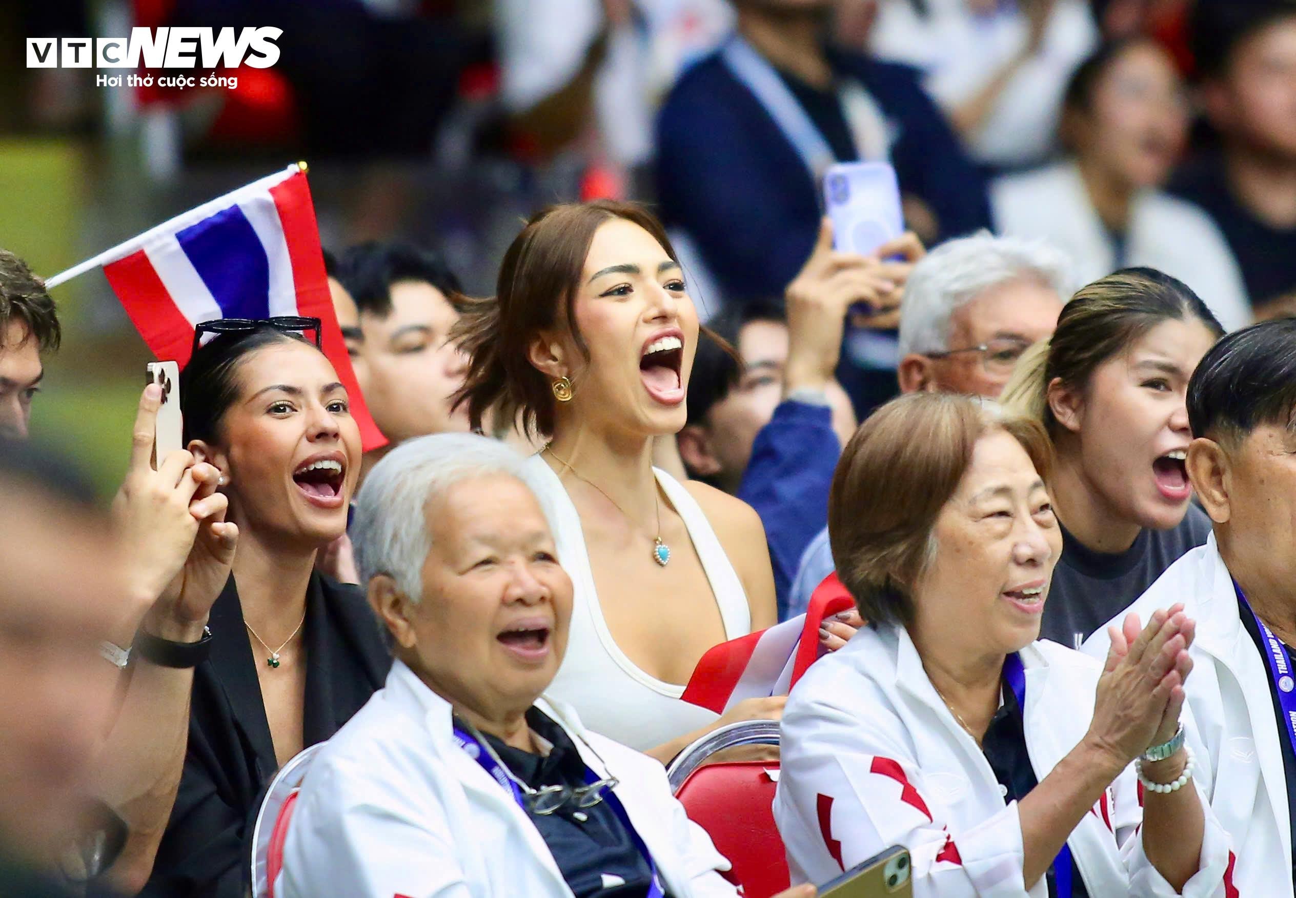 Phía chủ nhà Thái Lan cũng tiếp đón Việt Nam bằng 2 vị khách đặc biệt. Hoa hậu Hoàn vũ Thái Lan 2021 Anchilee Scott-Kemmis có mặt cùng Antonia Porsild - Á hậu 1 Hoa hậu Hoàn vũ thế giới 2023 (áo đen, bên trái). Trong sân, cả hai đội thi đấu quyết liệt, so kè từng điểm số. Cô nàng Anchilee Scott-Kemmis cũng không tránh khỏi cảm giác hồi hộp khi Thái Lan dẫn trước 2-1 về set nhưng bị Việt Nam thắng thế ở set 4. Cô nàng liên tục trao đổi với bạn bè về các cú đánh trên sân, nhất là ở các tình huống challenge. Anchilee Scott-Kemmis biểu cảm 