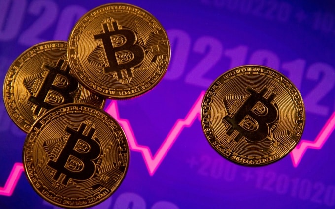 Các biểu trưng của Bitcoin được đặt trên màn hình đồ thị về giá. Ảnh: Reuters