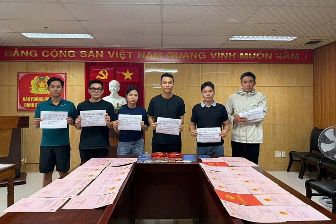 Nhóm lừa đảo do Vân (áo đen, đứng giữa) cầm đầu tại cơ quan công an. Ảnh: Tú Anh