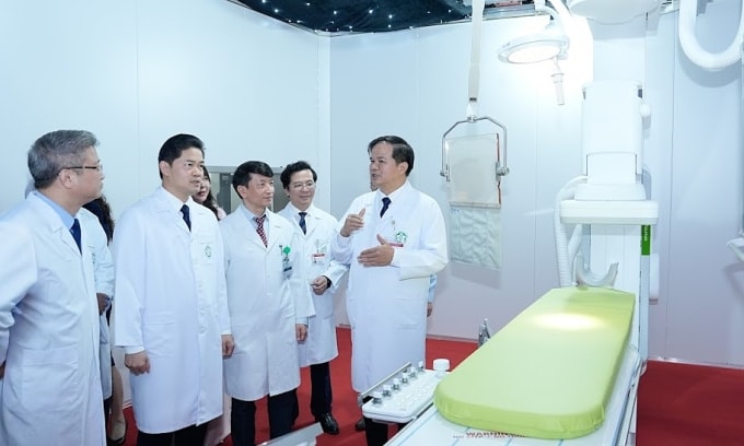 PGS Đào Xuân Cơ (trái) giới thiệu hệ thống máy móc vừa được lắp đặt tại Bệnh viện Bạch Mai. Ảnh: Thành Dương