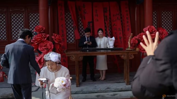 Các cặp mới cưới chụp ảnh tại một ngôi đền ở Bắc Kinh hôm 28/10. Ảnh: Reuters/Tingshu Wang