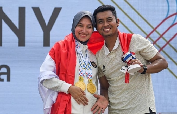 Dewi (trái) mừng 2 tấm HC vàng SEA Games 33 cùng chồng. Ảnh: Khaosod