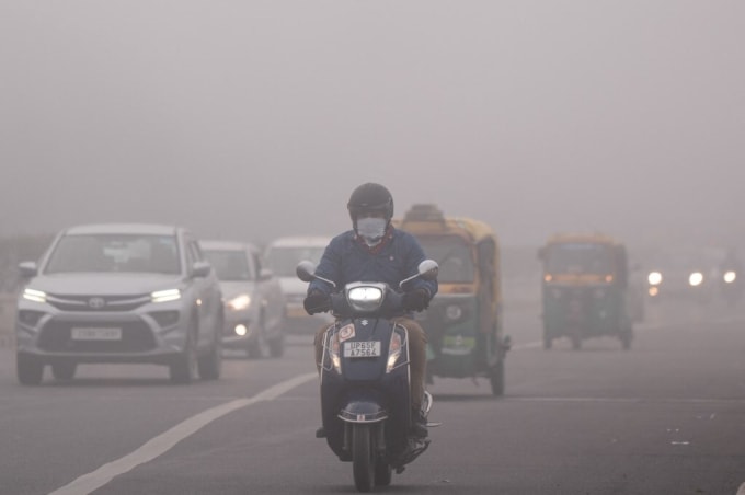 Người dân đeo khẩu trang di chuyển trên đường phố New Delhi, Ấn Độ, hôm 15/12. Ảnh: AFP