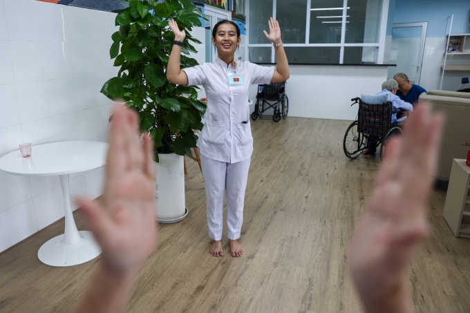 Nhân viên Bệnh viện Phục hồi chức năng - Điều trị bệnh nghề nghiệp TP HCM hướng dẫn người bệnh tập luyện. Ảnh: Quỳnh Trần