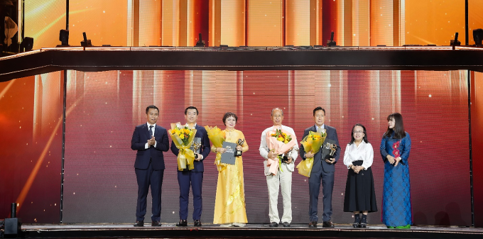 Bà Cao Thị Ngọc Dung (áo dài vàng) nhận bằng khen và cúp vinh danh từ ban tổ chức. Ảnh: Yến Linh