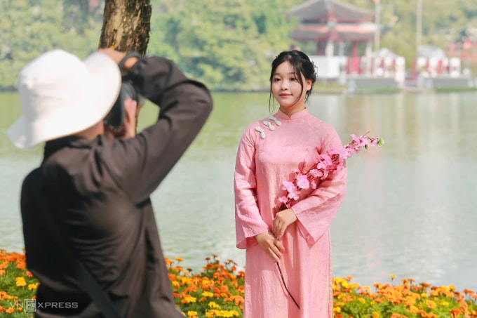 Thiếu nữ chụp ảnh tại hồ Gươm khi trời hửng nắng ngày 20/12. Ảnh: Gia Chính