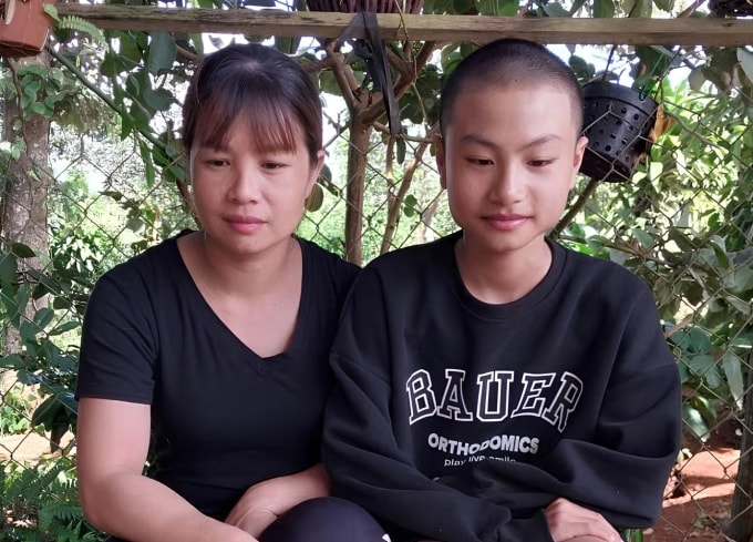 Mẹ con chị Mỹ ngồi ở sân nhà, trưa 21/12. Ảnh gia đình cung cấp